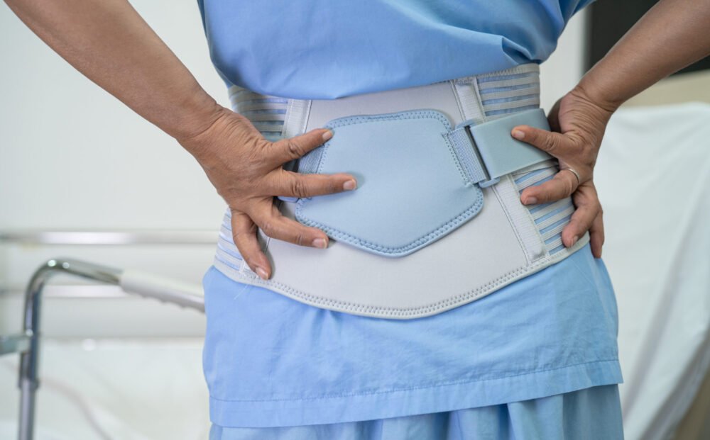 Asian lady patient wearing back pain support belt for orthopedic lumbar with walker.