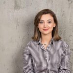 Portrait of a young smiling pretty girl in plaid shirt posing . High quality photo