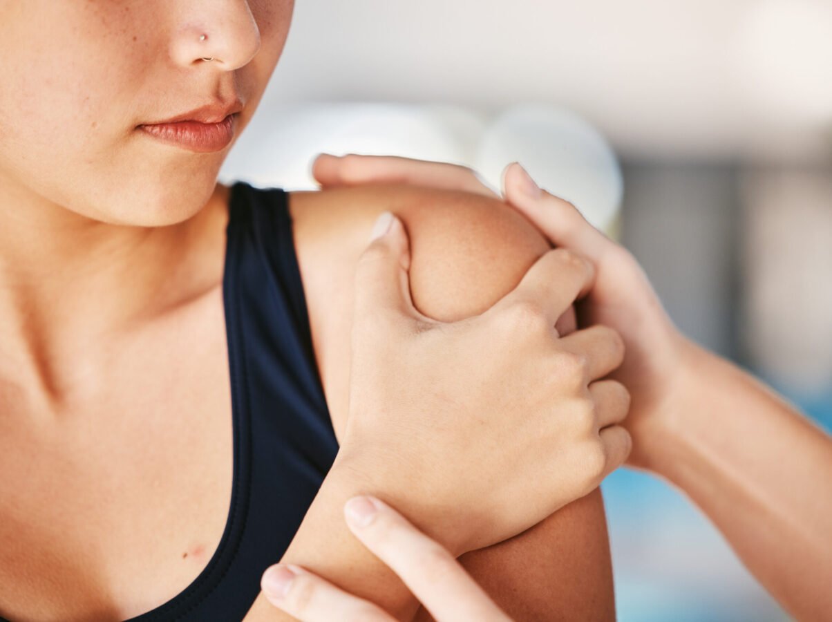 Woman, shoulder pain or girl swimmer with injury after exercise, training or workout accident in practice. Helping hands, sports athlete or closeup of person with tendinitis, muscle or broken bone.